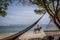 Black hammocks on the beach and a horse rider