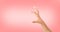 Black hand measuring invisible items or hold something, on pink background.Woman`s palm making gesture while showing