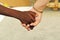 Black hand and white hand, adoption mother, interracial concept
