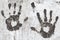 Black handprints on an old white wall. Silhouettes of the heart on the palms