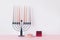 Black hannukia candlestick with nine multicolored candles, a donut and a gift on the white background. Celebration of Hanukkah