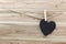 Black Heart hung on hemp rope isolated on wooden background.