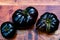 Black heirloom tomatoes on reddish wooden cutting board