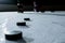 Black hockey pucks on the ice rink of the stadium. Athlete training in hockey on a dark ice arena, sports school. Winter