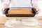 Black home pan. Ready made pastries. Raw dough. Wooden table. Kid hands