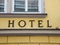 Black Hotel Text Sign on Yellow Building