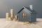 Black house with golden coin stacks on wooden and concrete background. Mortgage and loan concept.