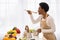 Black Housewife Cooking Preparing Healthy Dinner Tasting Meal In Kitchen