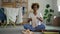 Black housewife woman folding clothes in stack on in living room. Female doing clean laundry