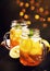 Black ice tea with lemon slice in glass jar on dark kitchen table background, summer cool soft drink, selective focus