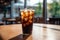 A black iced coffee on the table at a coffee shop