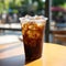 A black iced coffee on the table at a coffee shop