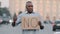 Black immigrant person holding cardboard slogan banner with text no, African American man standing in city disagree