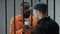 Black imprisoned gangster giving dollar cash to prison guard, bribery in jail