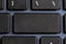 Black input button on the laptop keyboard, space for text.