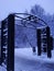 Black iron arch in the snow in winter, entrance to the Park