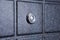 Black iron door of squares with silver peephole