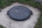 Black iron hatch on the sewer in gray concrete