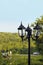 Black iron lamppost in park in vintage style on blurred background