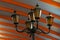 Black iron pole with lanterns and lamps under a striped ceiling