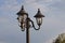 Black iron pole with three lanterns and lamps