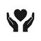 Black isolated icon of heart in hands on white background. Silhouette of heart and hands. Symbol of care, love, charity