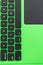 Black keyboard on a green laptop. keys with letters and numbers. Detail of a laptop computer. Image detail to describe IT tools,