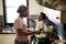 Black kid feeding mother with cooking food in the kitchen