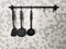 black kitchen ladles hanging on a gray wall