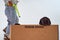 Black Labrador puppy peeks out of cardboard box for bananas