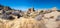 Black labrador retriever dog among boulders in Yucca Valley California on a sunny January day with blue sky near Joshua Tree