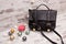 Black ladies handbag on a wooden background, Christmas ornaments, garland and candle.