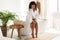 Black Lady Shaving Legs With New Safety Razor In Bathroom
