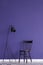 Black lamp and chair set on a violet wall in simple living room