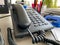 Black landline telephone with a tube, buttons and a wire on the work table at the office desk with office supplies. Business work