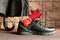 Black leather boot, umbrella from the rain, withering flower and red dried maple leaf as a symbol of the change of time of year
