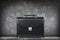 Black leather briefcase over gray wall