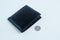 Black leather wallet with 5 baht coins on white background