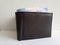 black leather wallet with mexican banknotes and white background