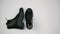 Black leather warm boots on a white background. Women`s winter boots with rough soles. Stop motion