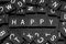 Black letter tiles spelling the word & x22;happy& x22;