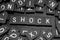 Black letter tiles spelling the word & x22;shock& x22;