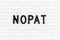 Black letter in word NOPAT Abbreviation of net operating profit after tax on white felt board background