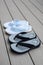 Black and Light Blue Flip Flops on Gray Deck Background