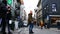 Black and light-skinned Europeans are walking along the street with white umbrellas