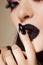 Black lips covered with rhinestones. Beautiful woman with Black lipstick on her lips and black and white manicure