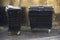 Black litter bins on wheels for rubbish in public housing estate