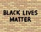 Black Lives Matter hand drawn graffiti sign on a brick wall. International human rights movement handwriting text. Social media