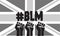 Black lives matter hashtag and fists on a black and white Union Jack background