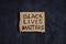 Black lives matter text on cardboard on dark background